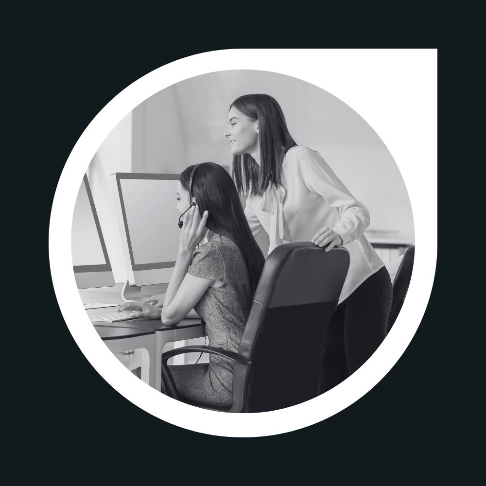 La imagen muestra una asesora que está instruyendo a una clienta en sus oficinas , lo que comúnmente llamamos como servicio de soporte tecnico presencial.